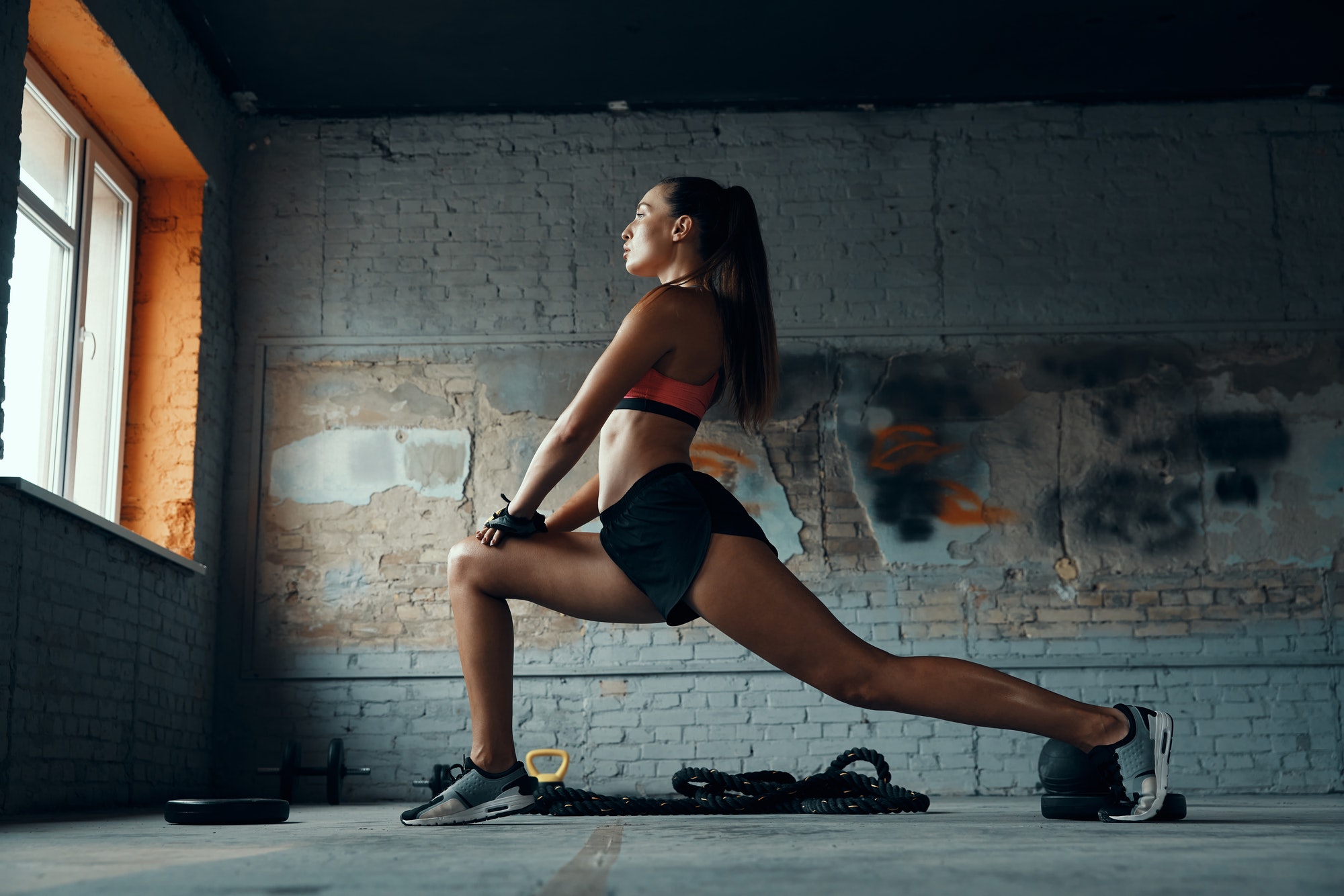 Beautiful young woman doing stretching exercises in gym